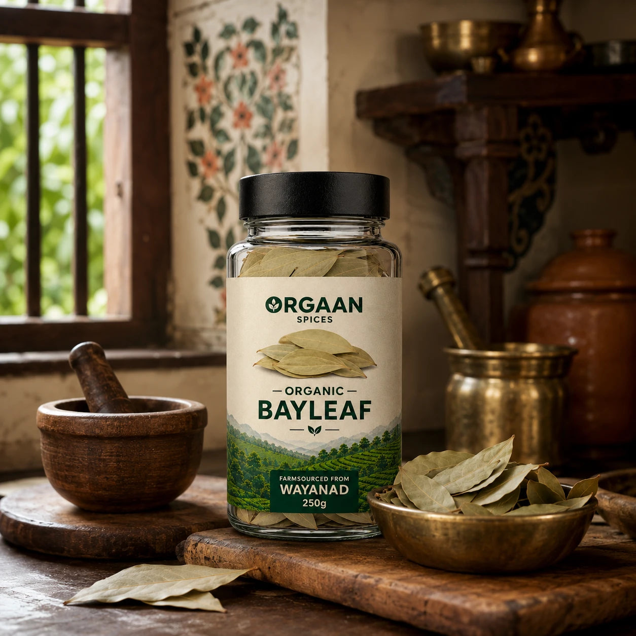 Jar of Orgaan Spices Organic Bayleaf on a wooden surface with traditional kitchen items.
