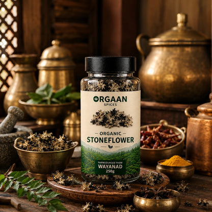 Bottle of Orgaan Spices Organic Stoneflower on a wooden surface with spices and herbs in the background.