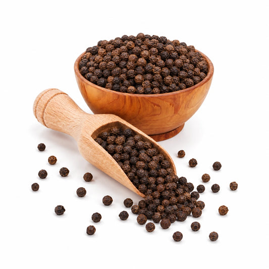Wooden bowl and scoop filled with black peppercorns on a white background