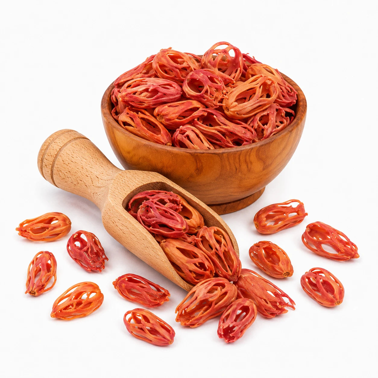 Wooden bowl and scoop filled with red dried fruit on a white background